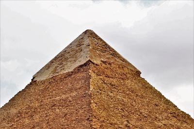 Low angle view of old building against cloudy sky