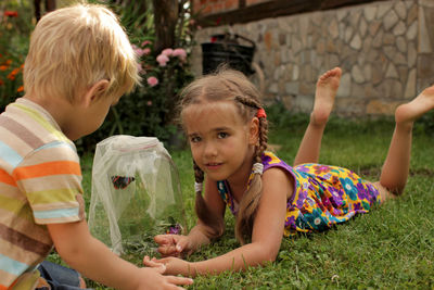 Cute sibling playing on grass at yard