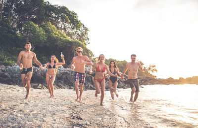 People enjoying on beach against sky