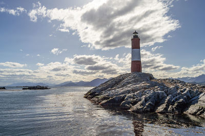 Lighthouse by sea against sky