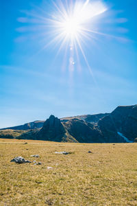 Scenic view of mountains against bright sun