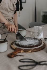 Woman cutting freshly baked chocolate cake