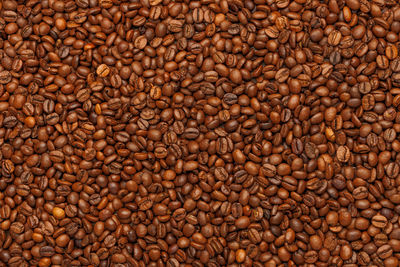 Full frame background and texture of roasted coffee beans on flat wooden surface