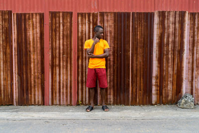 Full length of man standing against wall