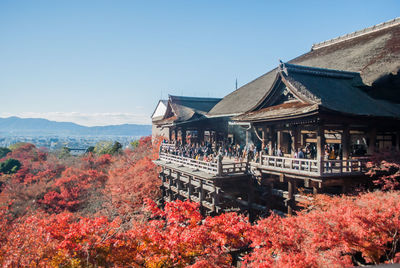 Temple by building against sky during autumn