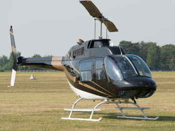 Helicopter on field against sky