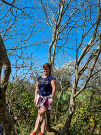 Portrait of woman standing by tree