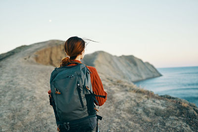 Rear view of woman looking at sea against sky