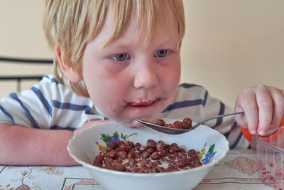 Portrait of cute boy with ice cream on table