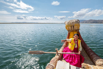 Woman on boat in sea against sky