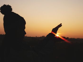 Silhouette man against orange sky during sunset