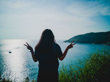 Rear view of woman looking at sea against sky