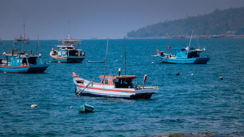 Boats sailing in sea against sky