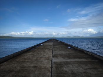 Pier over sea against blue sky