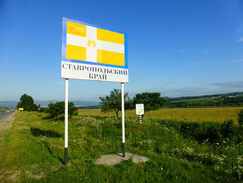 Information sign on field against sky