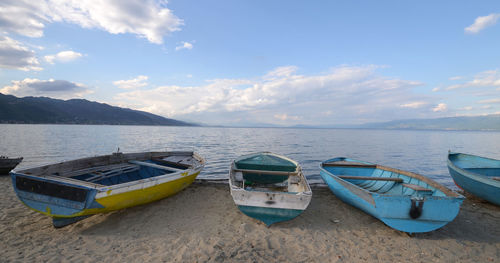 Boats moored in sea against sky