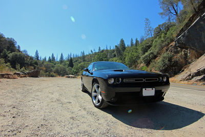 Car on road against clear blue sky