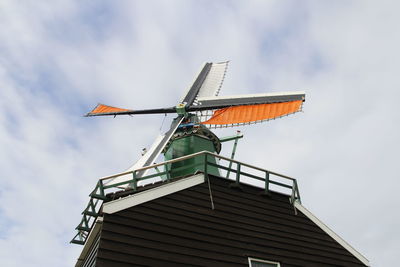 Traditional dutch windmill with the cloudy sky in spring at the zaanse schans, zaandam, netherlands