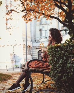 Woman sitting in park during autumn