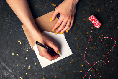 A woman writes plans for 2022 on black background top view