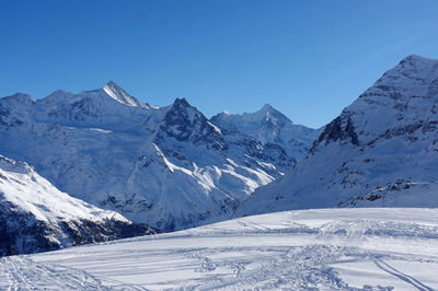 Scenic view of snowcapped mountains against clear blue sky