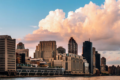 Buildings in city against cloudy sky