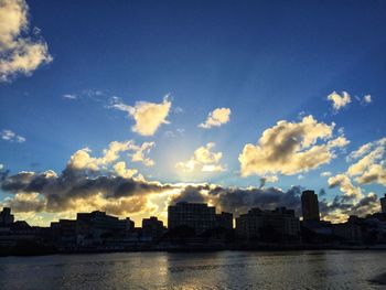 Buildings in city against sky during sunset