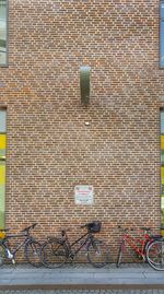 Bicycle parked against brick wall