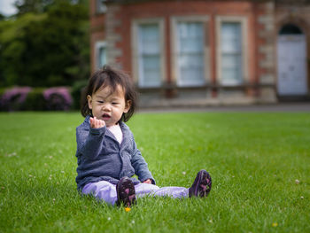 Portrait of young girl sitting on lawn