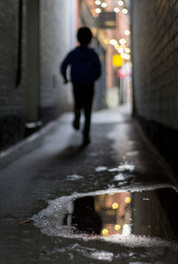 Rear view of man standing on street in city