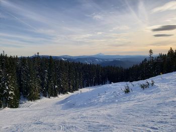 Snow covered land against sky during winter