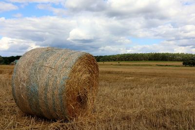 Hay bales on field against sky