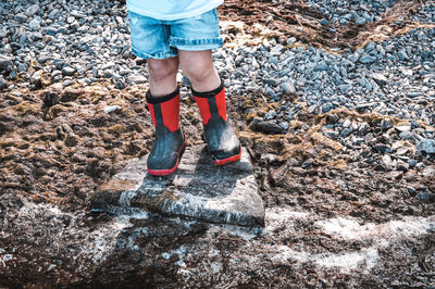 Low section of woman standing on rock