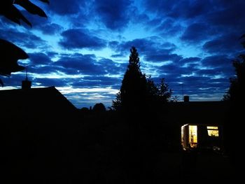 Low angle view of silhouette house against sky at night