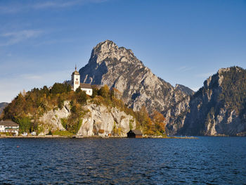 Scenic view of sea by buildings against sky