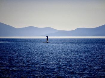 Man paddleboarding in sea