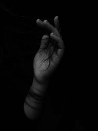 Close-up of woman hand over black background