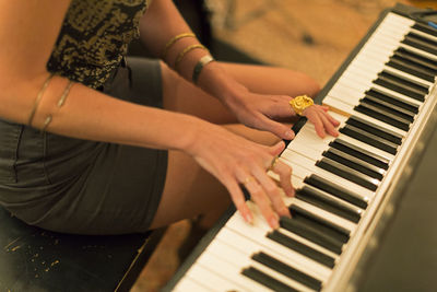 Hands of a young woman playing a keyboard