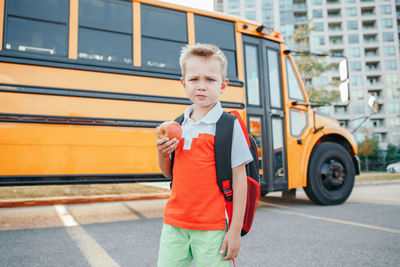 Kid standing by bus on street