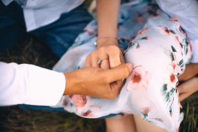 Midsection of couple holding hands