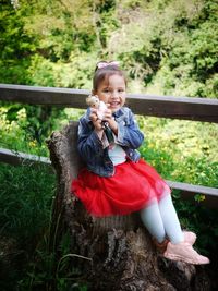 Portrait of smiling girl sitting on plant