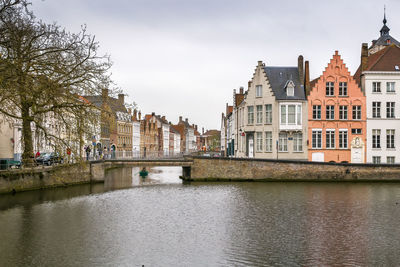 Historical houses on canal embankment in bruges, belgium