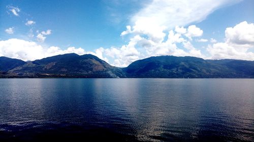 Scenic view of sea and mountains against sky