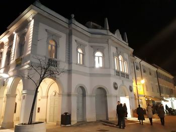 People in front of building at night