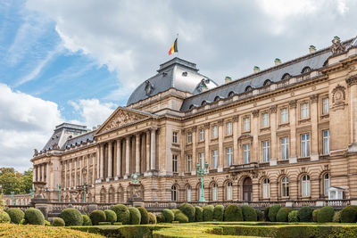 Facade of historical building against cloudy sky