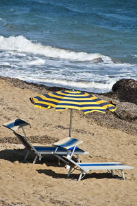 Deck chairs on shore at beach