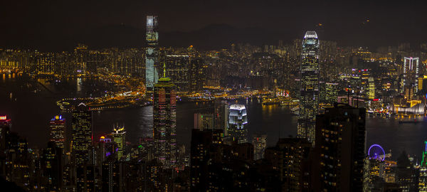 Illuminated cityscape against sky at night