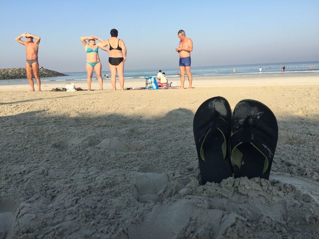 PEOPLE SITTING ON BEACH