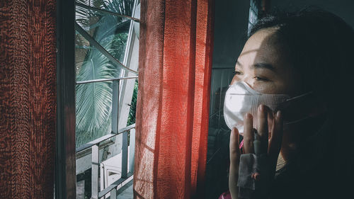 Close-up portrait of a young woman drinking glass window