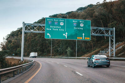 Cars on highway in american usa city country. road to new york. green blue street signs to ny city